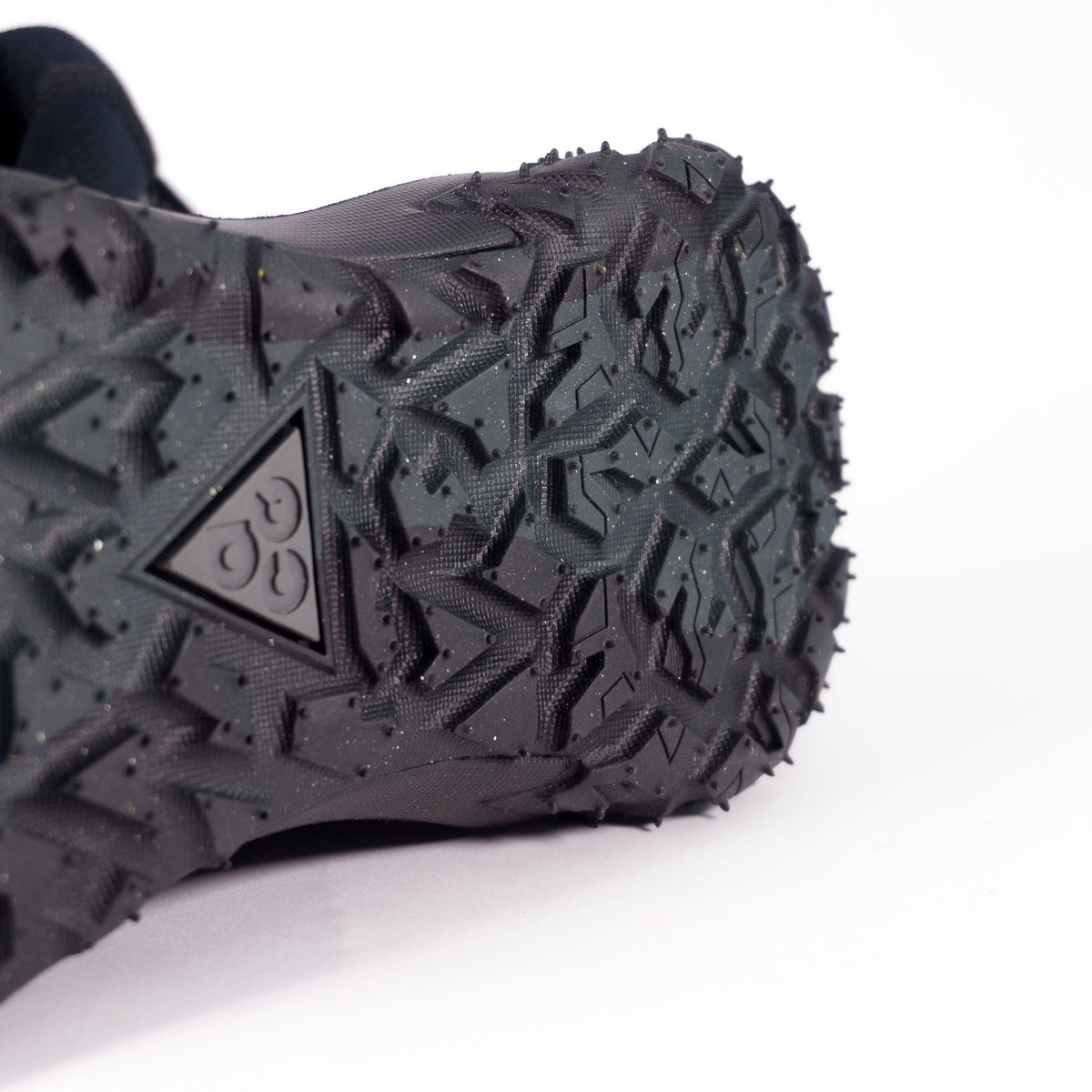 Агресивний протектор Nike ACG Mountain Fly 2 зблизька — шипи і трикутний логотип ACG на підошві