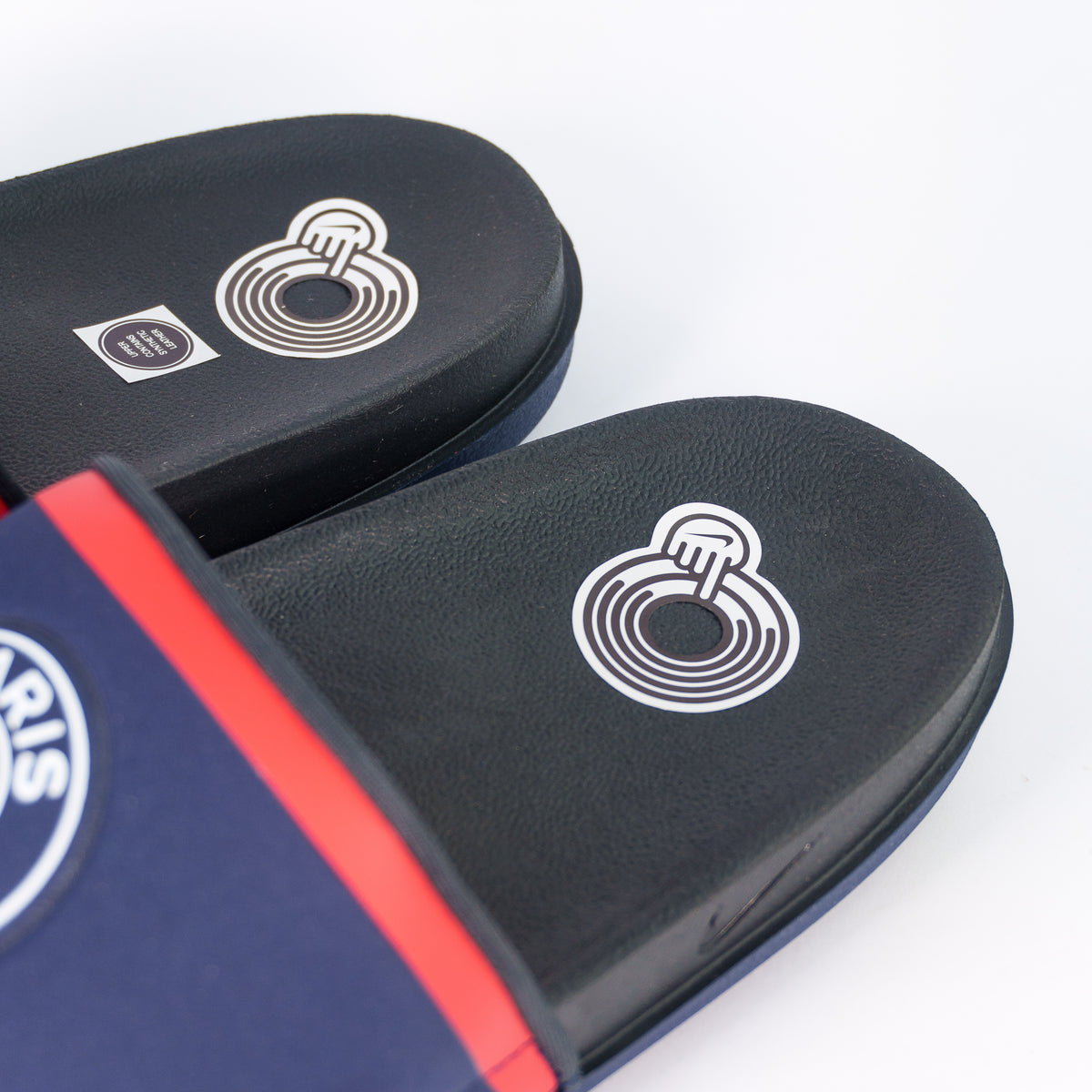Устілка тапочок Nike PSG Offcourt Slide зблизька — білий принт у формі кілець