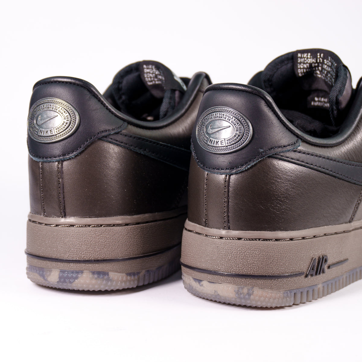 Nike Air Force 1 Low Black Tea and Petra Brown — вид ззаду, металевий медальйон Nike на чорній п'ятці
