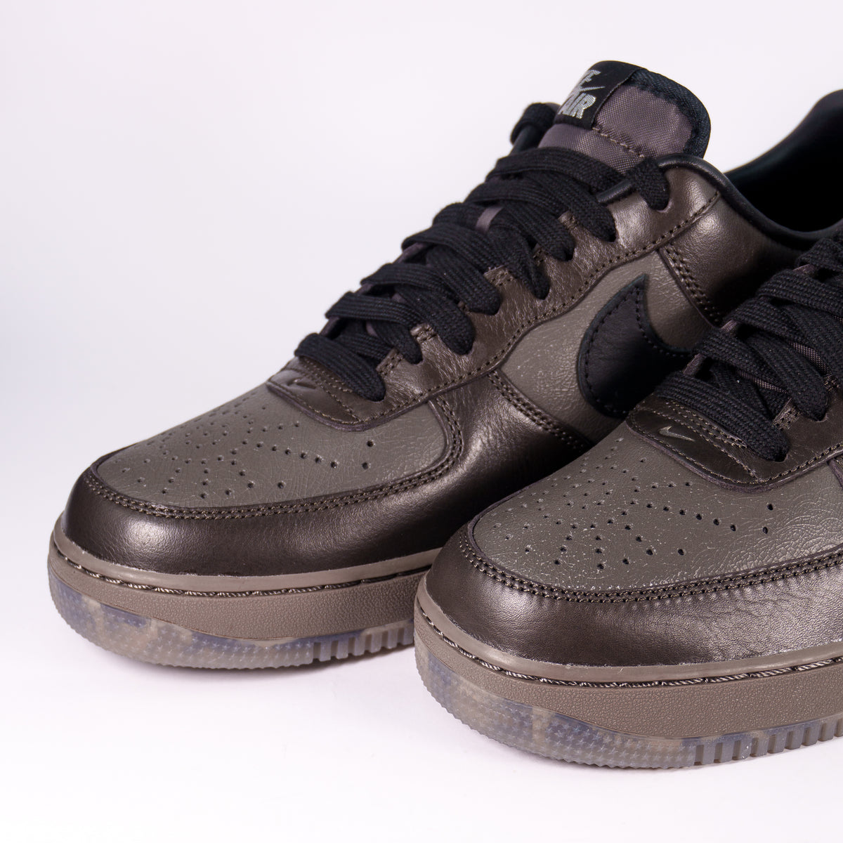 Носки Nike Air Force 1 Low з глянцевої коричневої шкіри крупним планом, перфорація і строчка