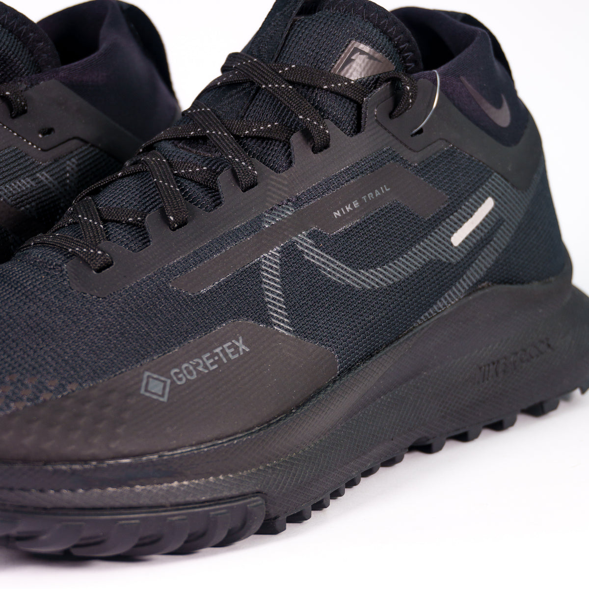 Бічна панель Nike Pegasus Trail 4 V2 зблизька: логотип GORE-TEX, напис Nike Trail і рефлективні вставки