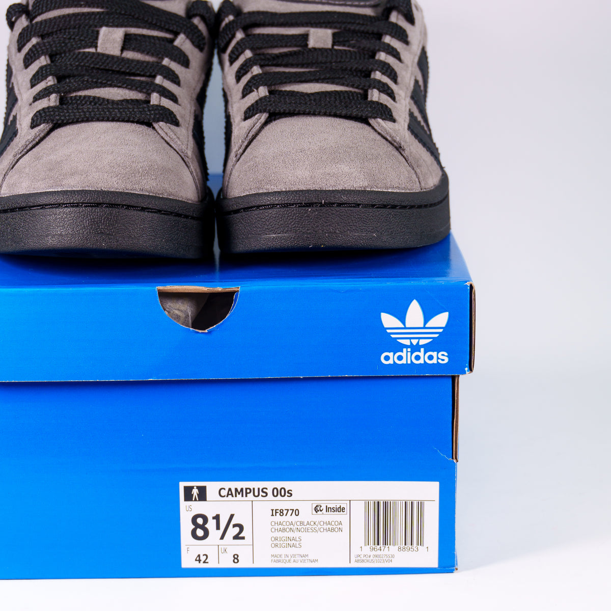 Adidas Campus 00s Charcoal на синій коробці Adidas з етикеткою IF8770