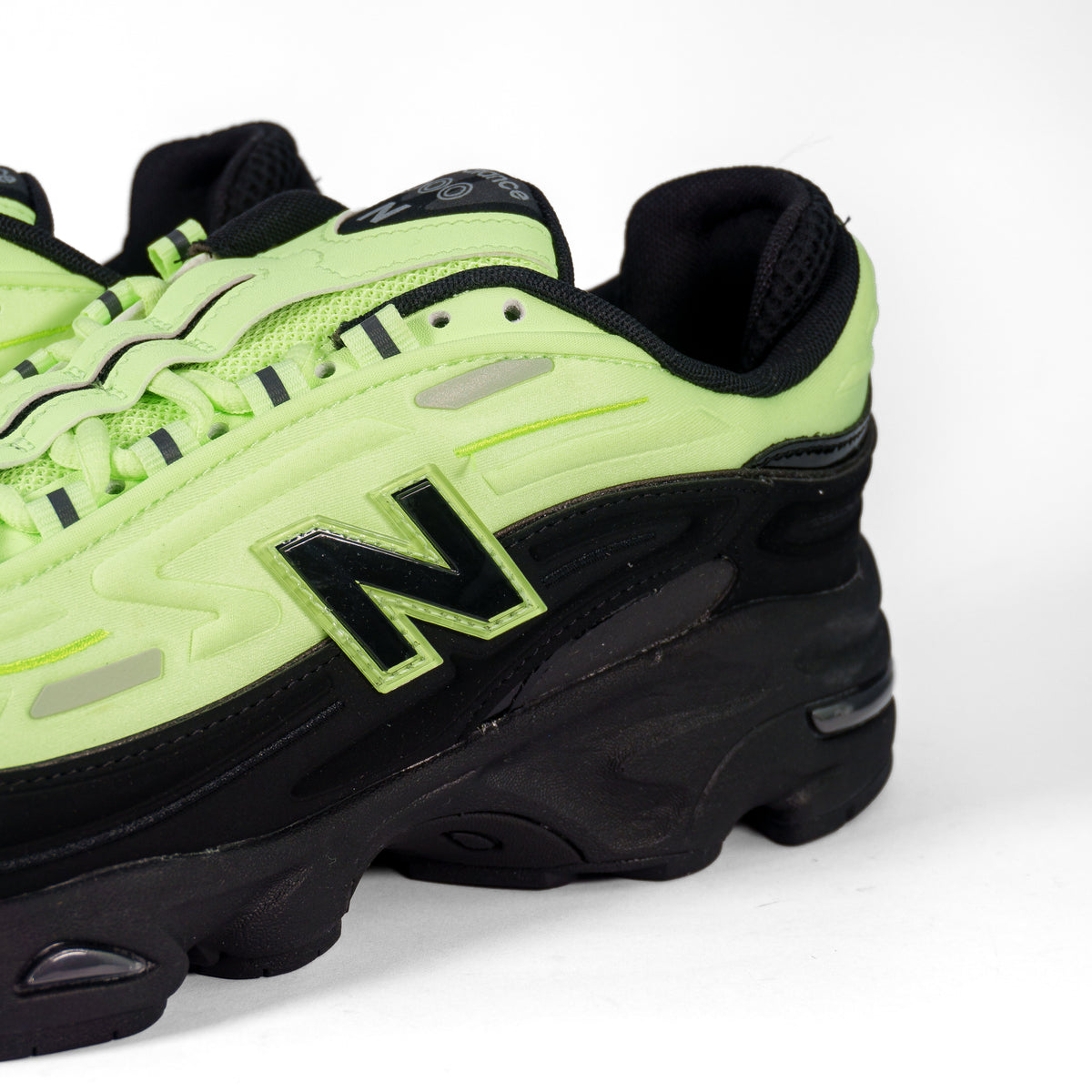 Боковина New Balance 1000D зблизька: чорна літера N з салатовим кантом на неоновому верху