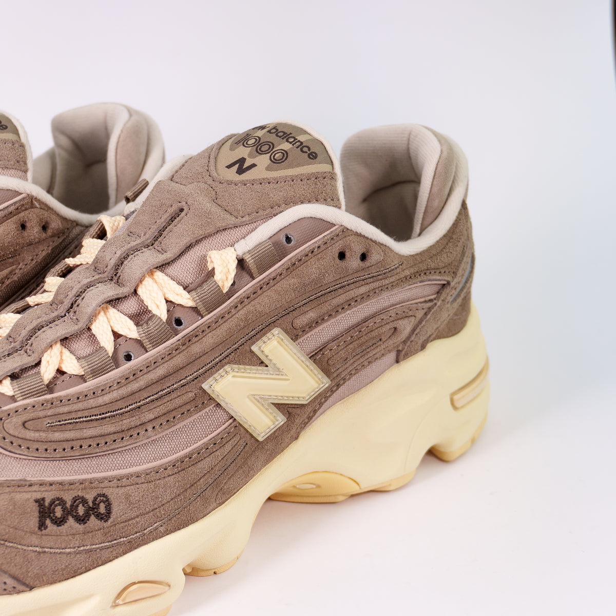 Бічна панель New Balance 1000 Mushroom зблизька: кремова N, вишитий номер 1000 і хвиляста замша