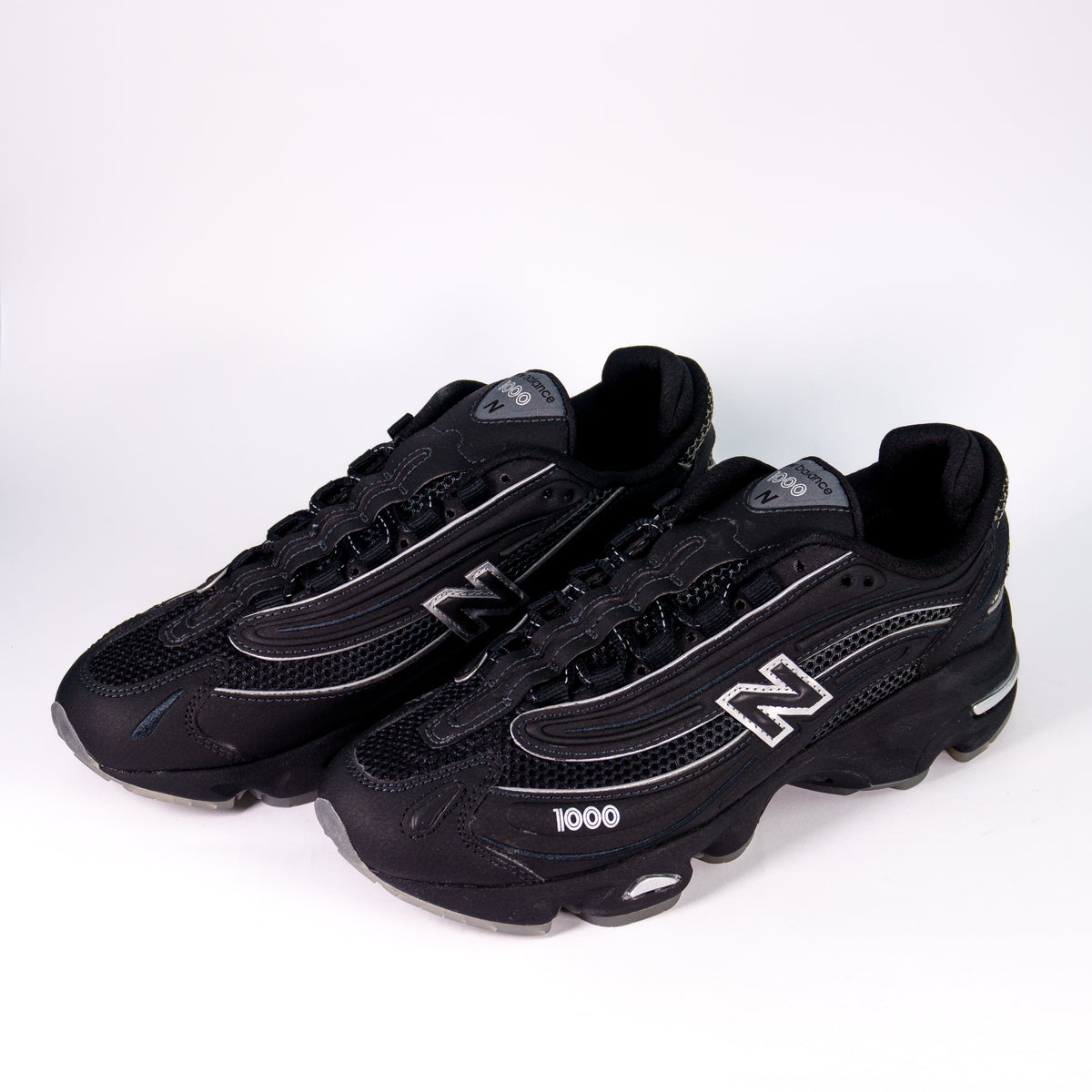 Пара чорних кросівок New Balance 1000 Black Lunar Pack — ракурс три чверті спереду