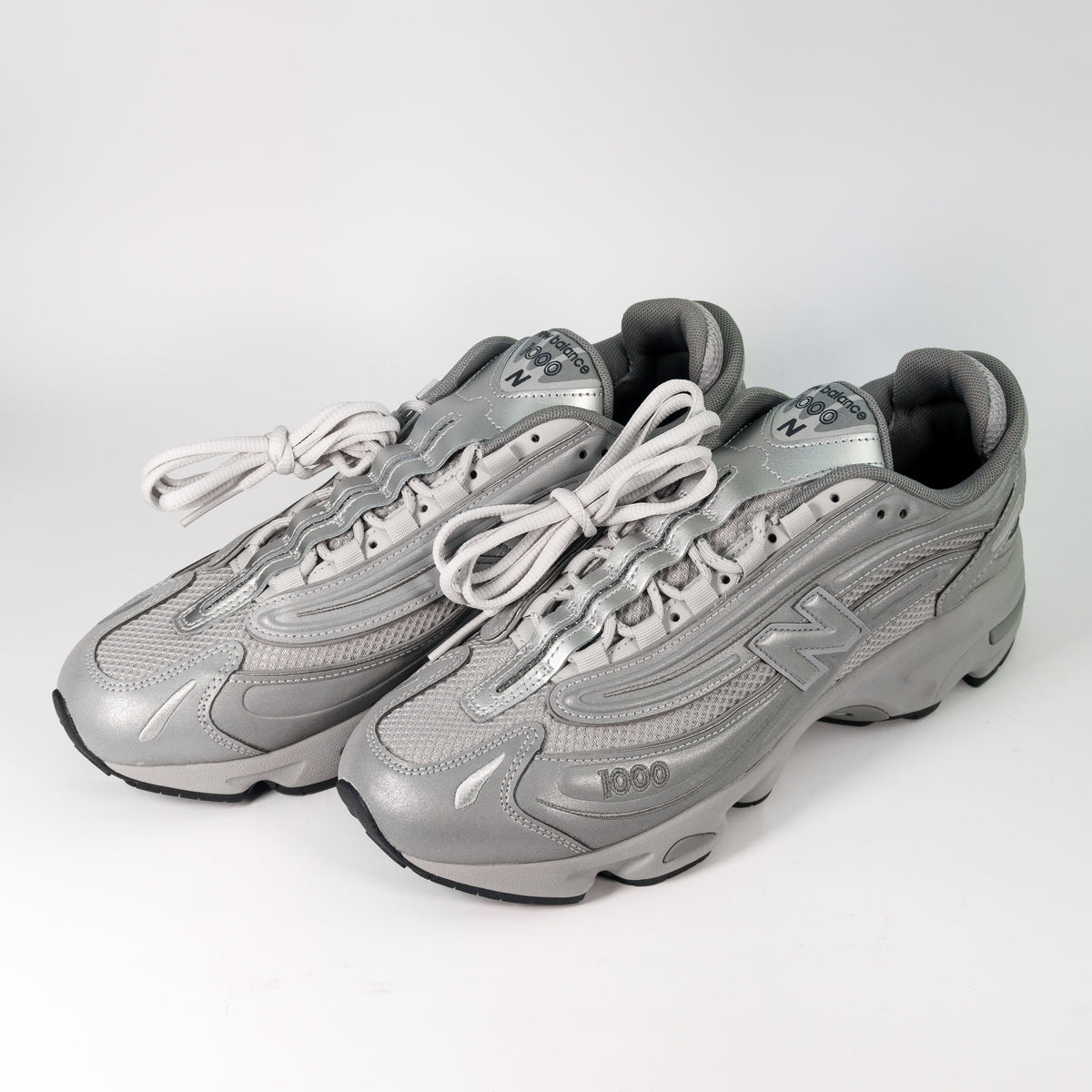 Пара сірих кросівок New Balance 1000 Reflective Pack Raincloud Grey — ракурс три чверті спереду