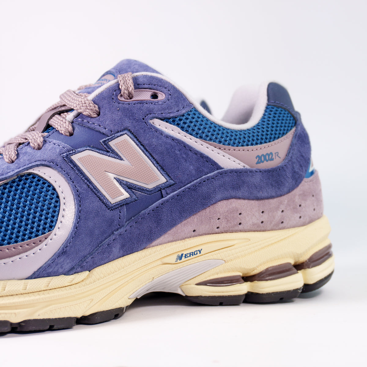 Боковина New Balance 2002R зблизька: бузкова N, синя сітка, замша і напис 2002R