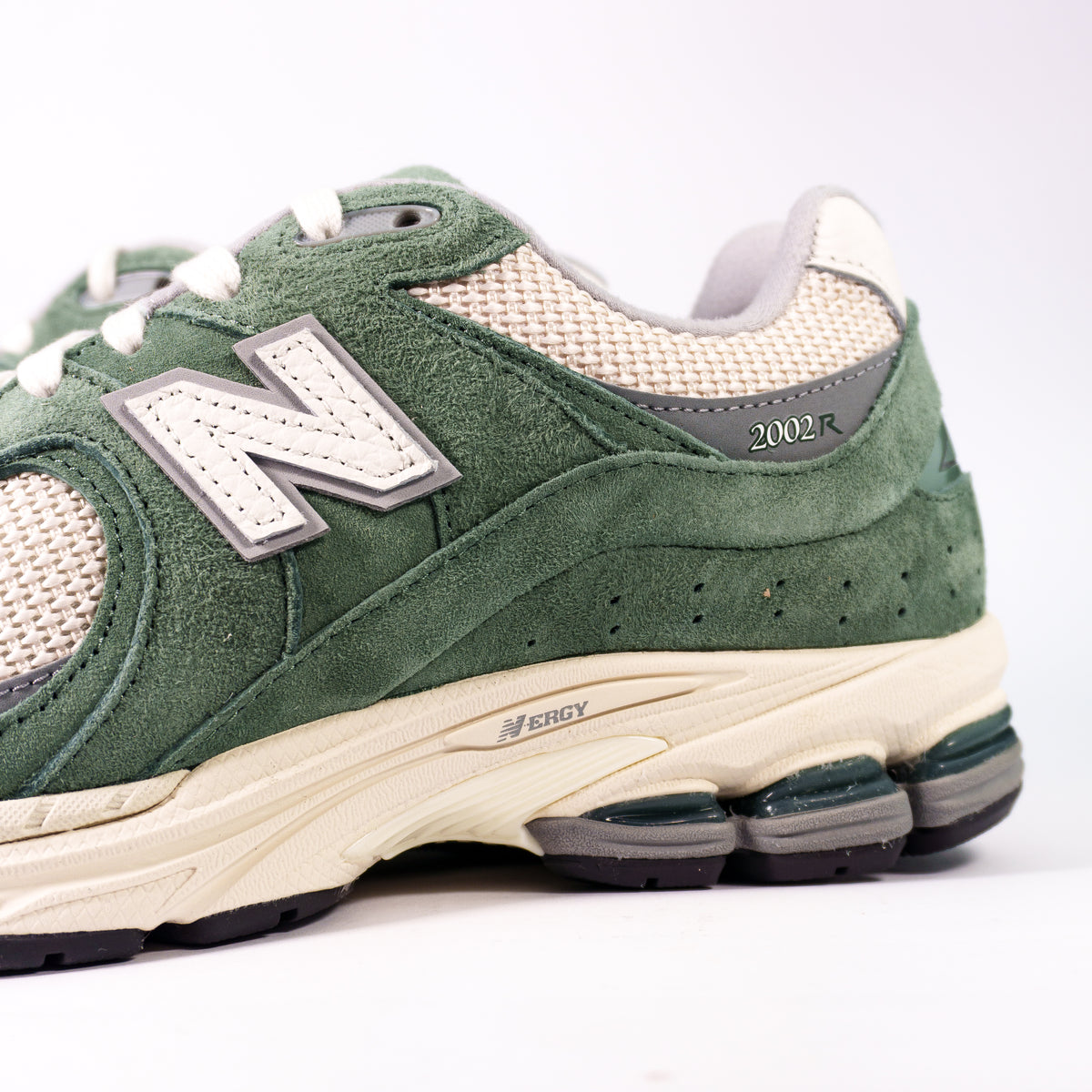 Боковина New Balance 2002R Green White зблизька: біла N з сірим кантом і золотий напис 2002R